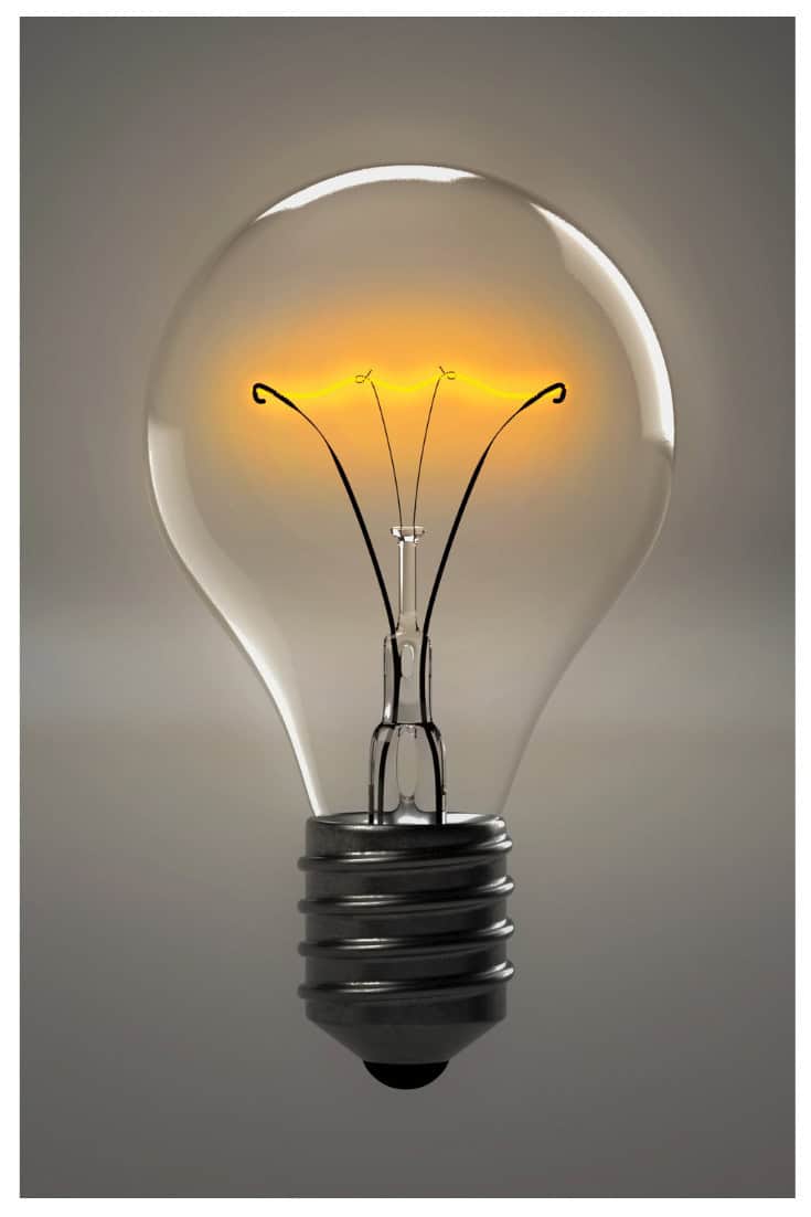 A lit incandescent light bulb with a glowing filament, reminiscent of ideas sparked by mom advocates, set against a neutral background.