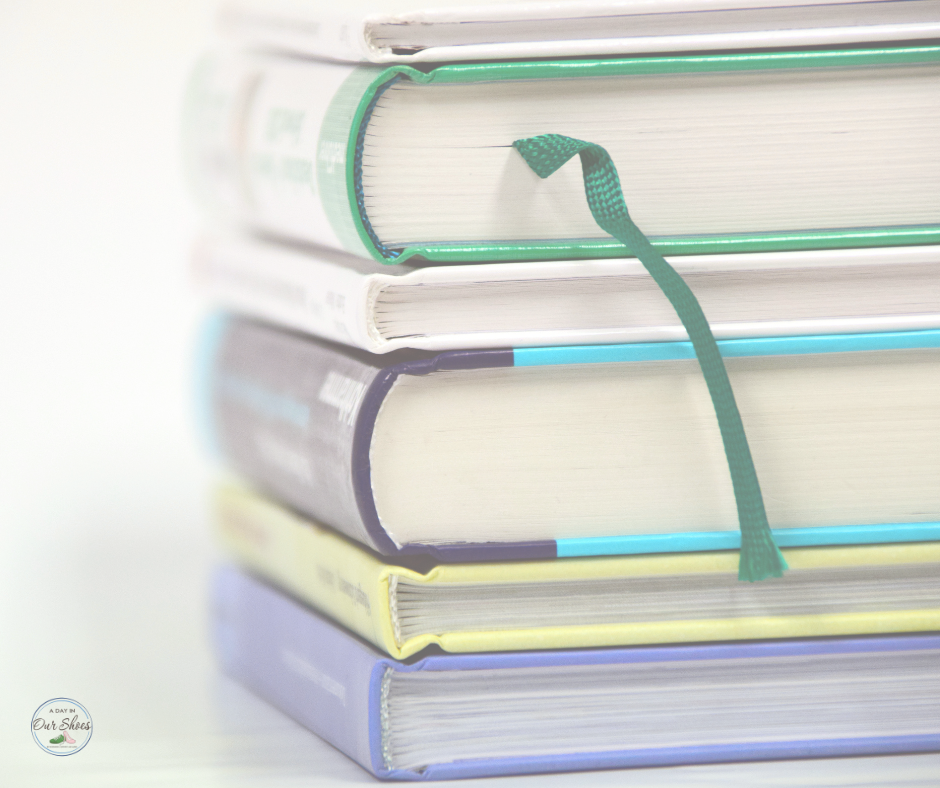 A stack of five hardcover books with varied colored spines and a green ribbon bookmark sits quietly, each whispering its own story. Special factors like unique textures and colors make this collection feel as personalized as an iep designed just for you.