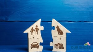 Divorced parents disagree on the iep- two wooden house-shaped puzzle pieces, one with icons of a family and car, the other with a dog and money, symbolize common divorce custody issues set against a blue wooden background.