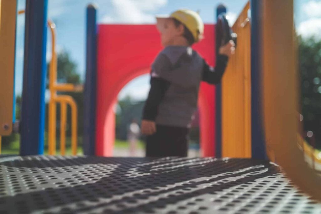 A young boy is enjoying himself on an ada-accessible playground.