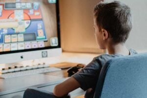 A young boy engrossed in a video game on a computer.