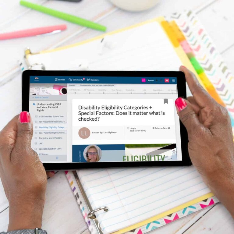Hands holding a tablet displaying a webpage about what age ends an iep, surrounded by colorful stationery on a white desk.