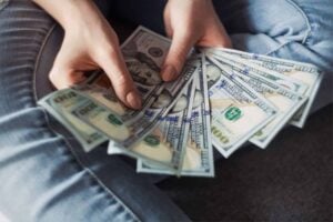 A woman is holding a bunch of money in her hands, wondering how much special education advocates cost.