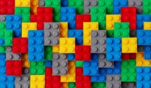 An assortment of colorful plastic building blocks, including red, yellow, blue, green, and gray pieces, stacked in a random overlapping pattern—perfect for following along with your lego instructions.