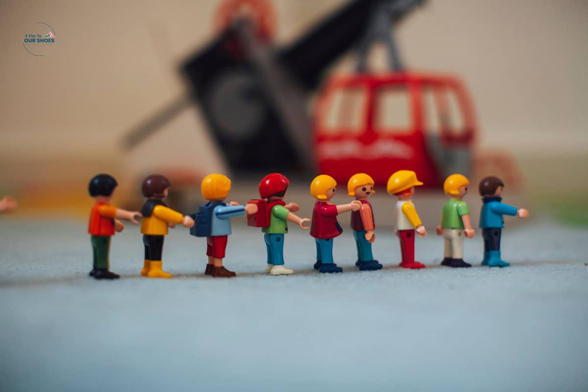 A row of colorful toy figures stands side by side, as if part of sequencing pictures. A red and black toy helicopter is blurred in the background.