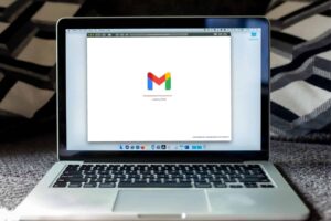 Laptop on a striped blanket with gmail loading on the screen, pivotal for parent communication plan discussions.