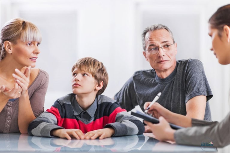 Parents and school student sitting in an iep meeting reviewing the graduation decision