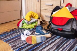 A child's backpack and shoes, contributing to the development of executive function skills, are neatly placed on a cozy rug in a room.