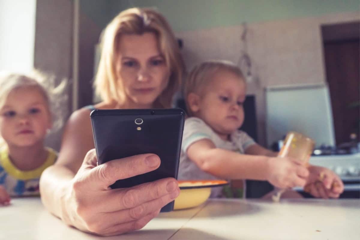 A stay at home mom showing her children how to make money using a cell phone.
