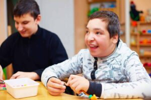 Happy kids with disability develop their fine motor skills at rehabilitation center for kids with special needs