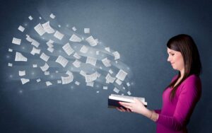 A woman in a purple shirt holds an open book emitting floating pages, showcasing dynamic vocabulary interventions against a dark background.