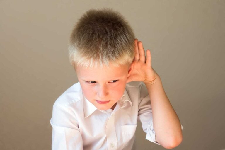 Young boy listening closely, representing phonological and phonemic awareness skills in early reading