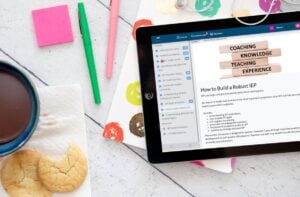An ipad with cookies and a cup of coffee next to it, displaying information on education salary.
