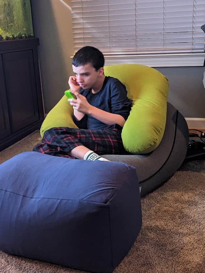 Autistic teenager enjoying his sensory bean bag chair that he got as a gift