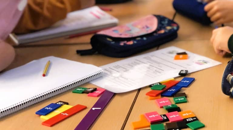 Students using hands-on math manipulatives during a kinesthetic learning activity in an elementary classroom