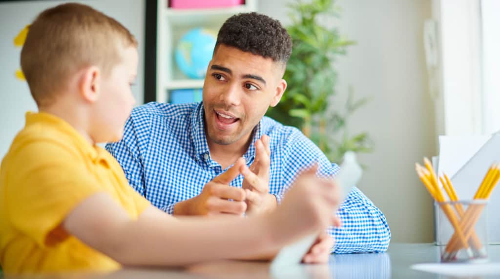 Teacher supporting student with emotional regulation strategy in classroom
