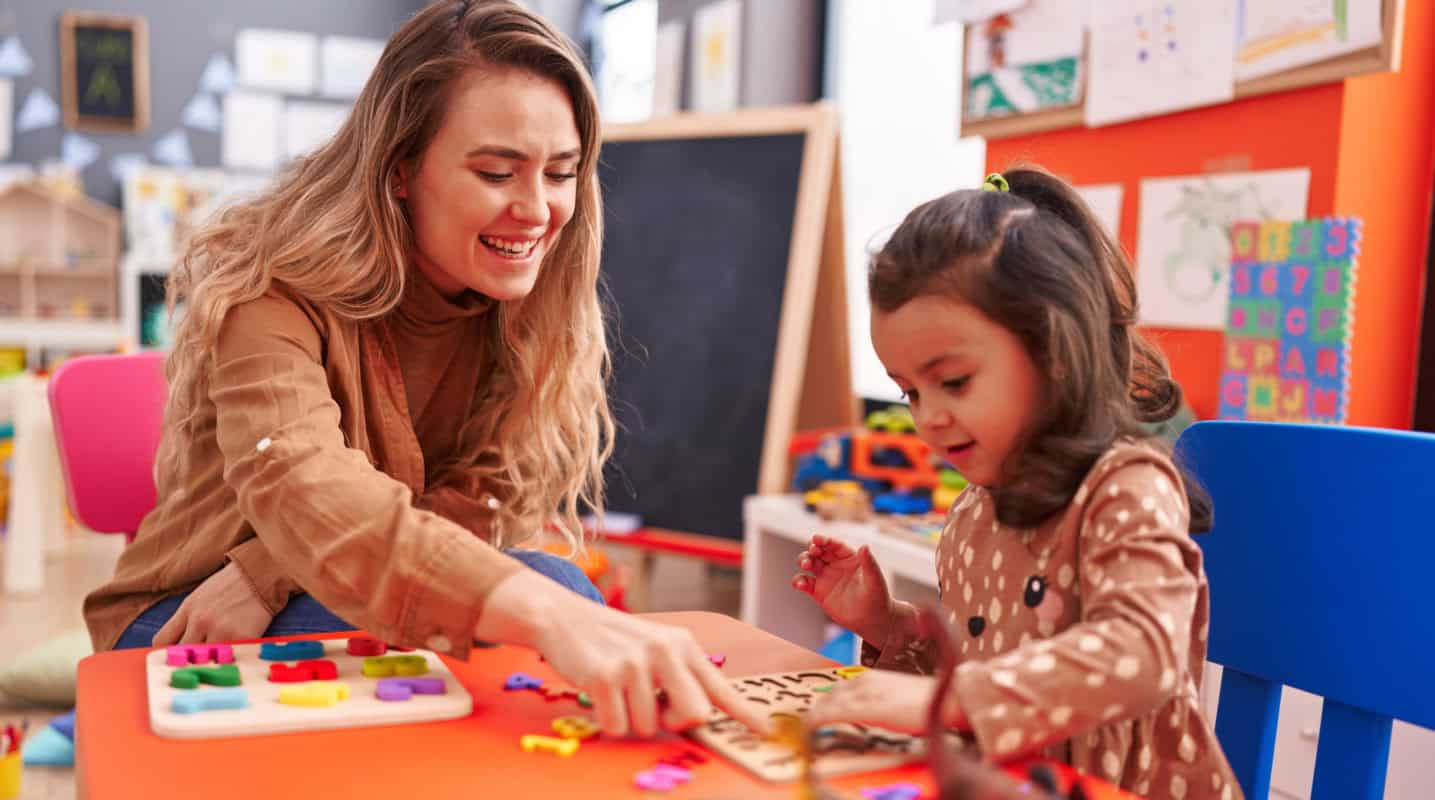 Teacher and child playing a game as part of aba therapy in the classroom