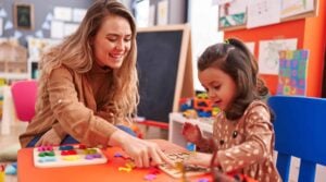 Teacher and child playing a game as part of aba therapy in the classroom