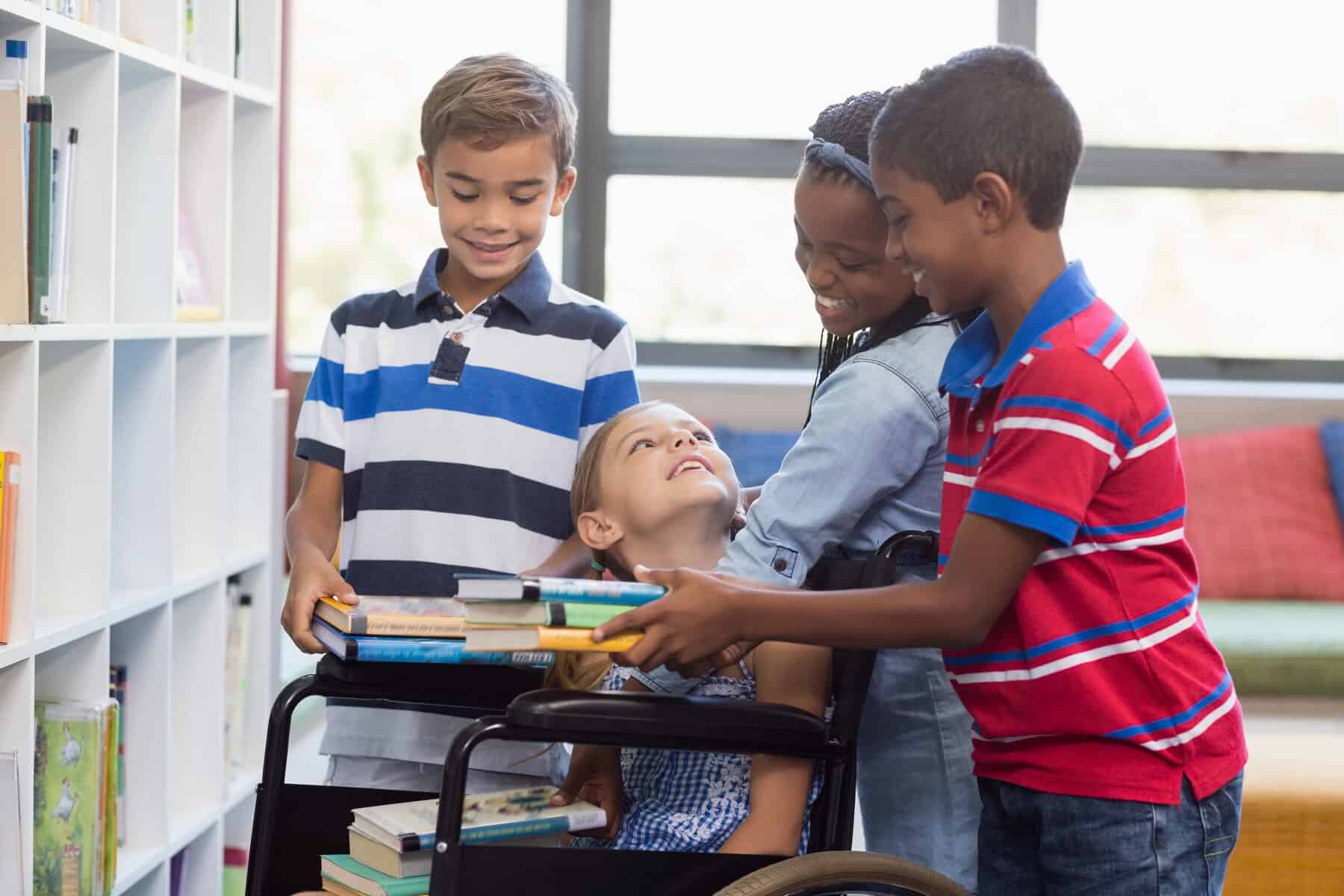 Four children are in a library, one using a wheelchair. As they share books, the scene subtly highlights the pros and cons of a 504 plan by showcasing inclusivity and support. Shelves filled with books and a sunlit window serve as the serene backdrop to this heartwarming exchange.
