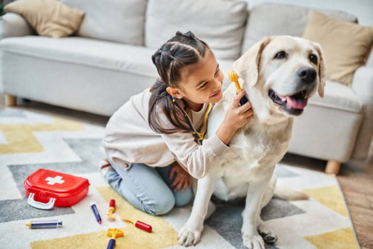 Child playing with a therapy dog for autism support at home.