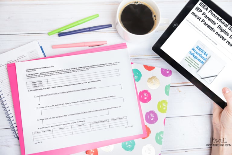 A person holding a tablet displaying an article about idea procedural safeguards, with paperwork, colorful pens, a coffee cup, and a notebook on a desk—highlighting how families can push back when schools question private evaluations.