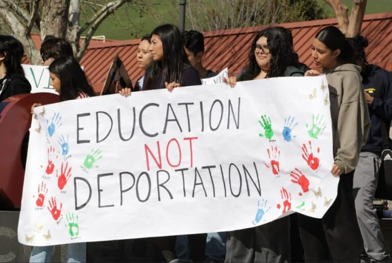 Protesters holding a banner that reads “education not deportation” during a demonstration supporting immigrant students and families.