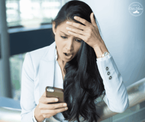 Parent reading a stressful email on her phone about a school manifestation determination meeting