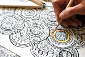 Hand coloring a detailed mandala coloring page with colored pencils for relaxation and stress relief