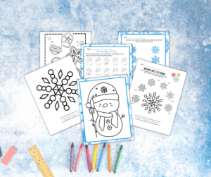 A set of winter coloring pages with a snowman coloring page and snowflake coloring page, complete with crayons and pencils.