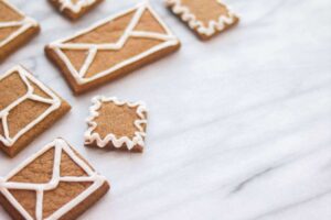 Gingerbread cookies with icing decorated with envelopes on a marble surface, perfect for christmas letter ideas.