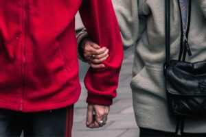 Two strangers find respite by holding hands on the street.