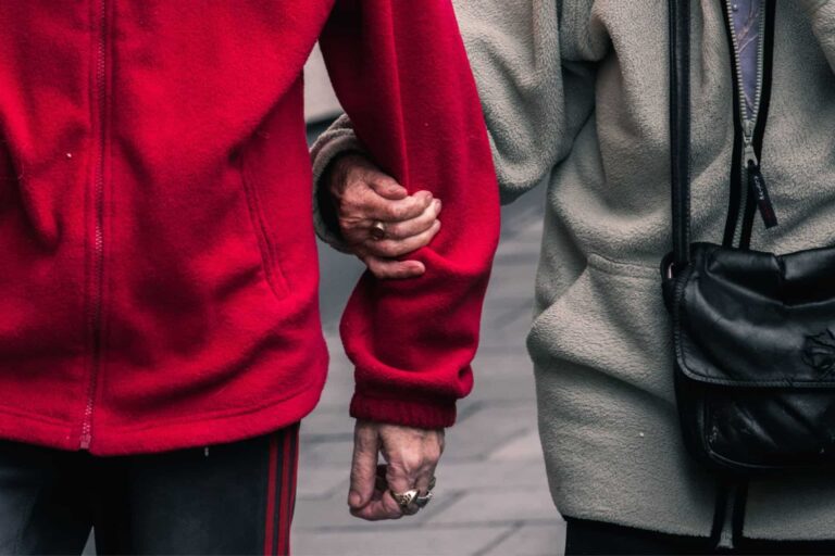 Two strangers find respite by holding hands on the street.