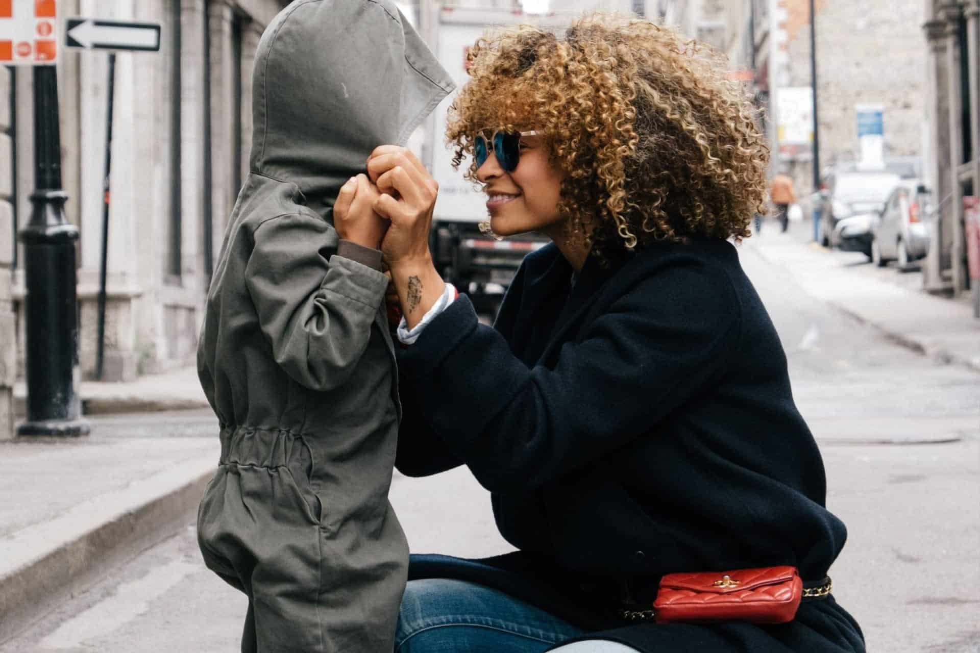 A woman with curly hair is hugging her son on the street in a heartwarming video.