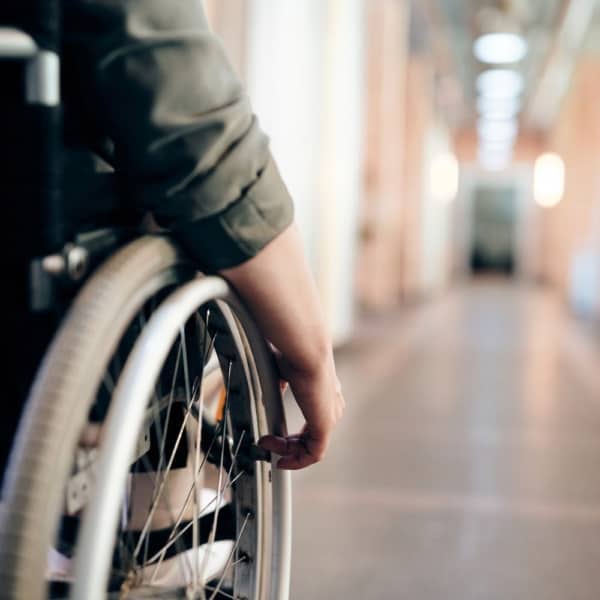 Student in a wheelchair going down a school hallway
