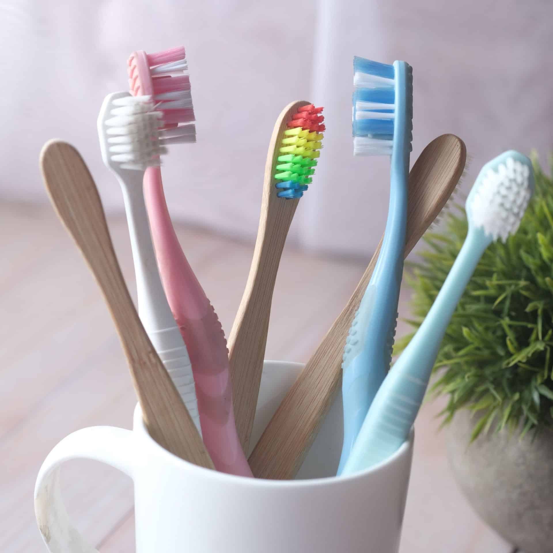 Brightly colored toothbrushes in a mug promote health and hygiene.